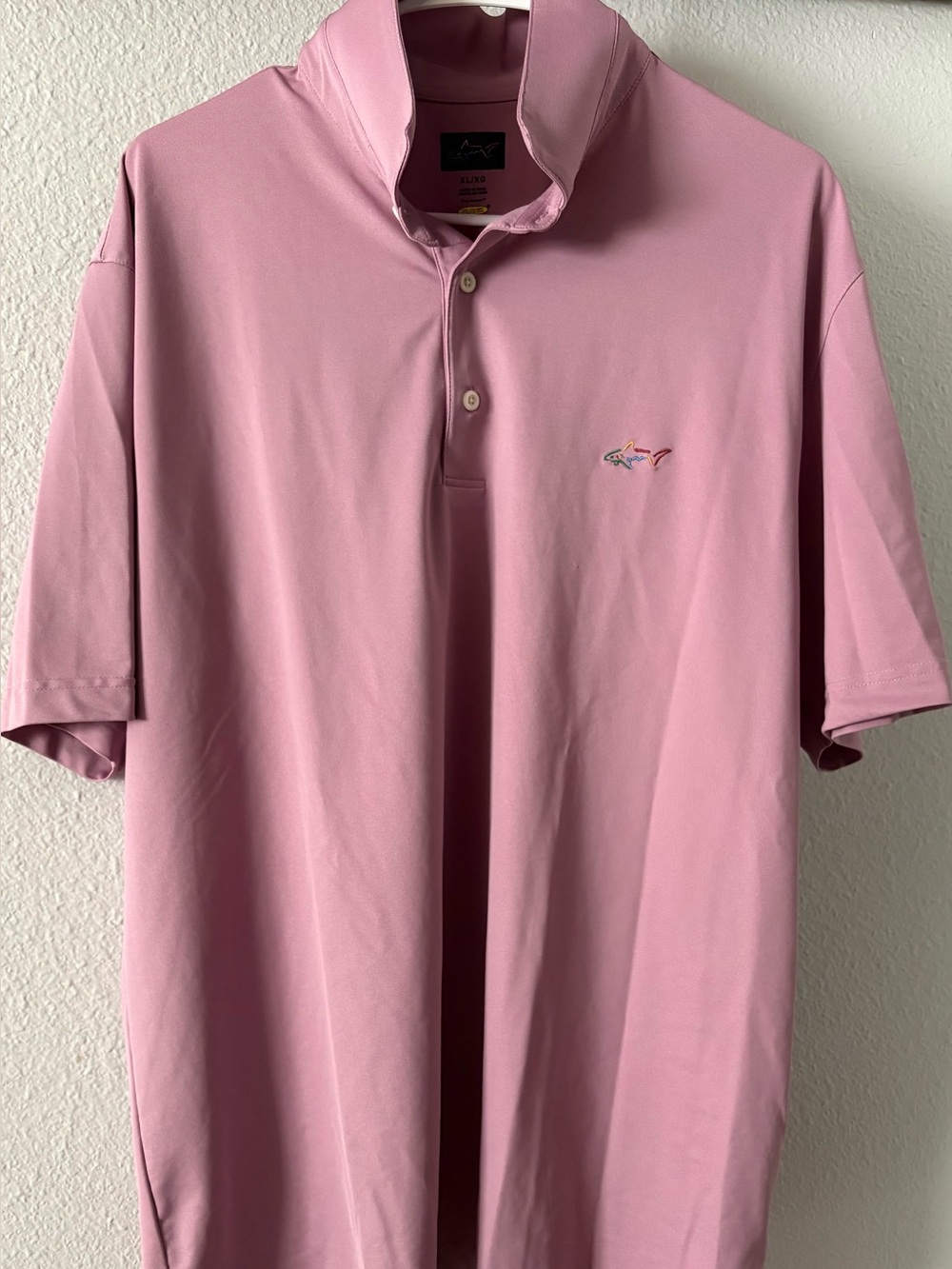 Greg Norman men’s short-sleeve performance golf polo shirt in a pink coral shade